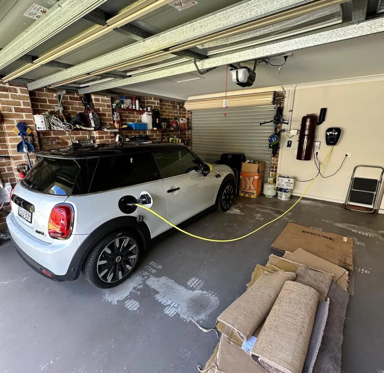 Mini Cooper electric vehicle charging in a residential garage with a wall-mounted charger in Sydney